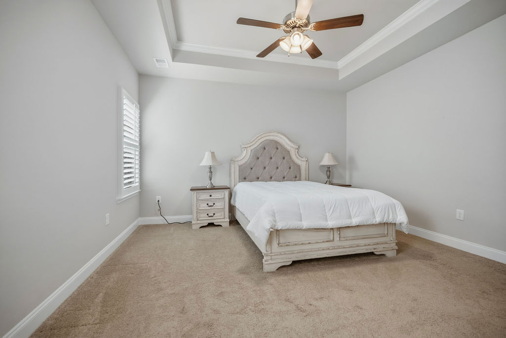 139 Olde Towne Drive Anderson, SC 29621 - Photo 13 of 26 This spacious bedroom features a high tray ceiling, carpeted flooring, and a large window with white blinds.