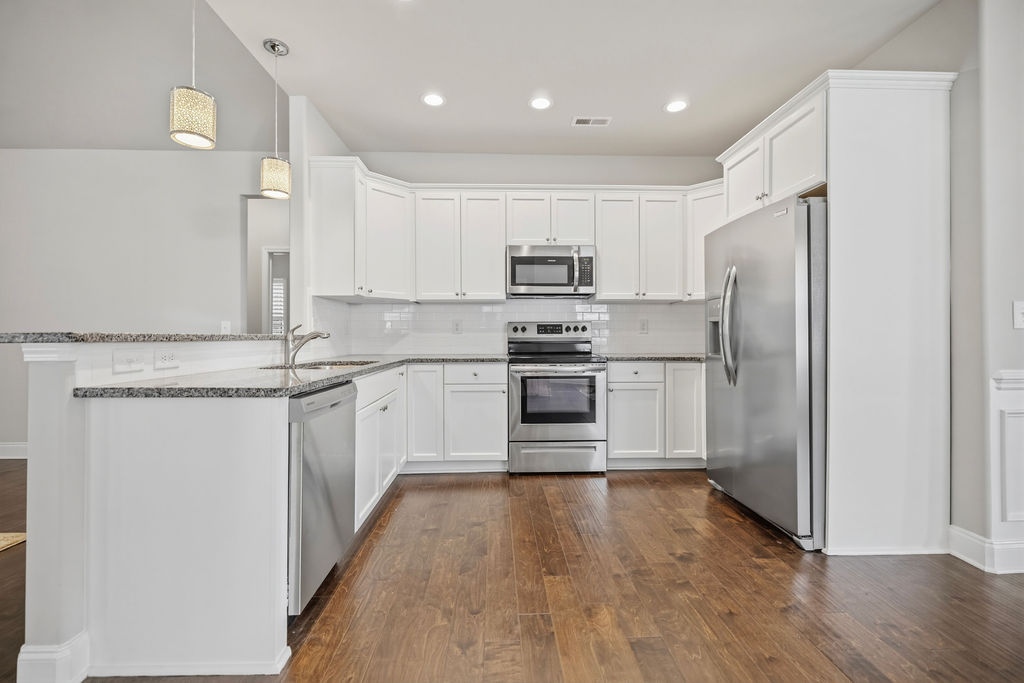 139 Olde Towne Drive Anderson, SC 29621 - Photo 4 of 26 This bright kitchen features wood floors, white cabinetry, and stainless steel appliances.