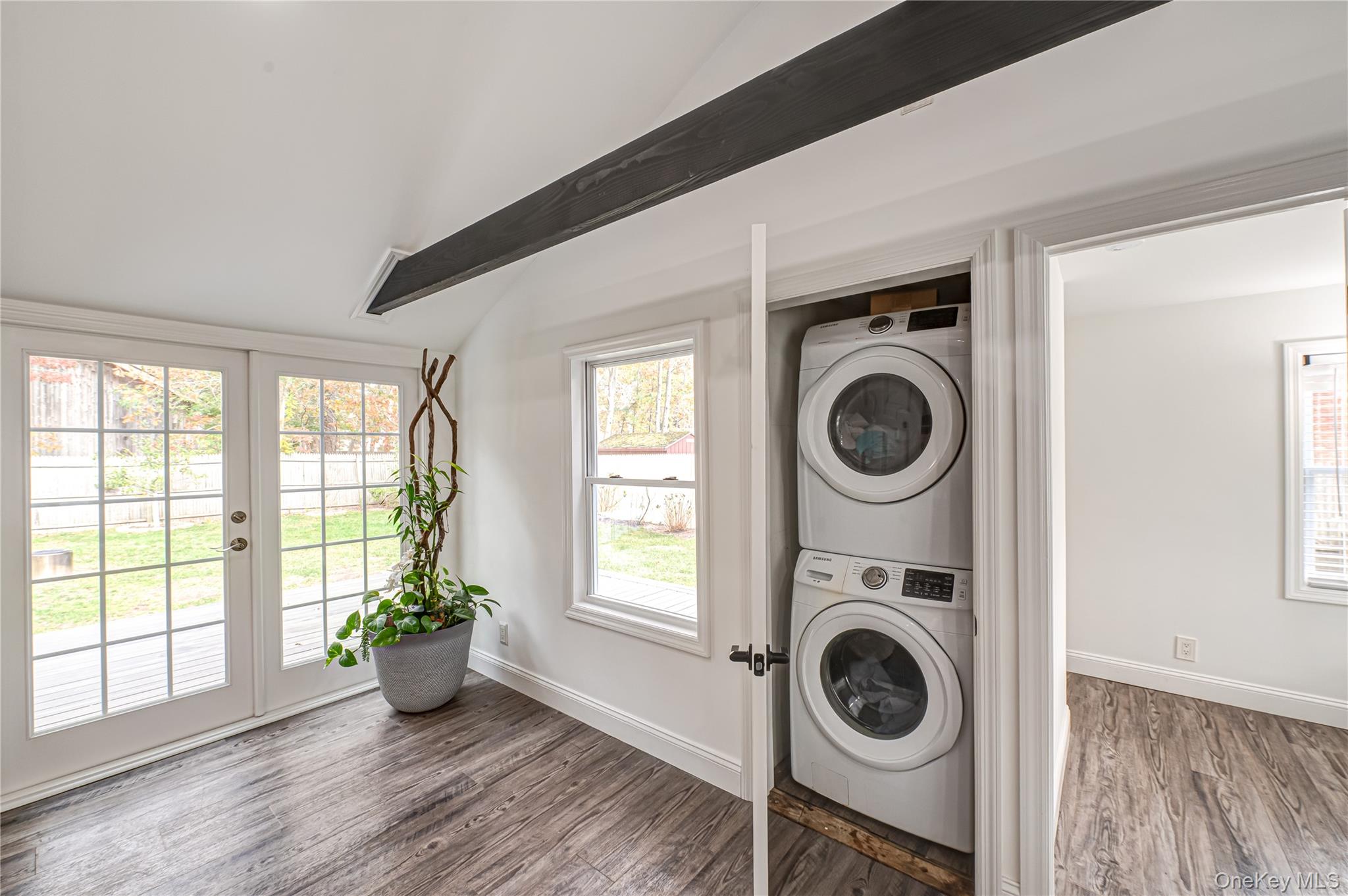 39 Lynncliff Road Hampton Bays, NY 11946 - Photo 11 of 34 Washroom with wood finished floors, estacked washer and dryer, plenty of natural light, and french doors