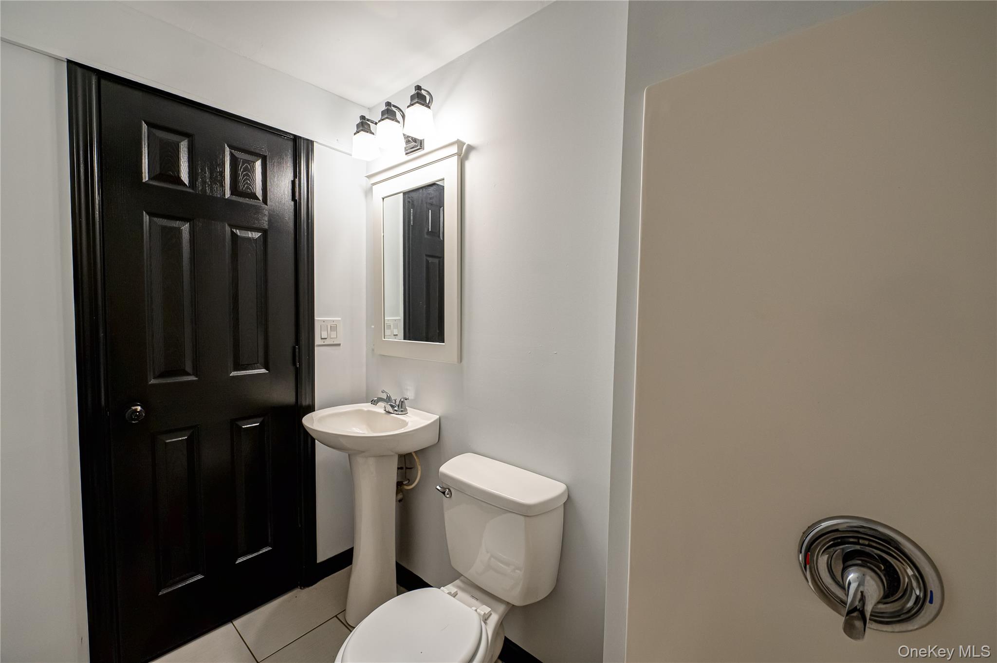 39 Lynncliff Road Hampton Bays, NY 11946 - Photo 15 of 34 Half bathroom with tile patterned floors and toilet