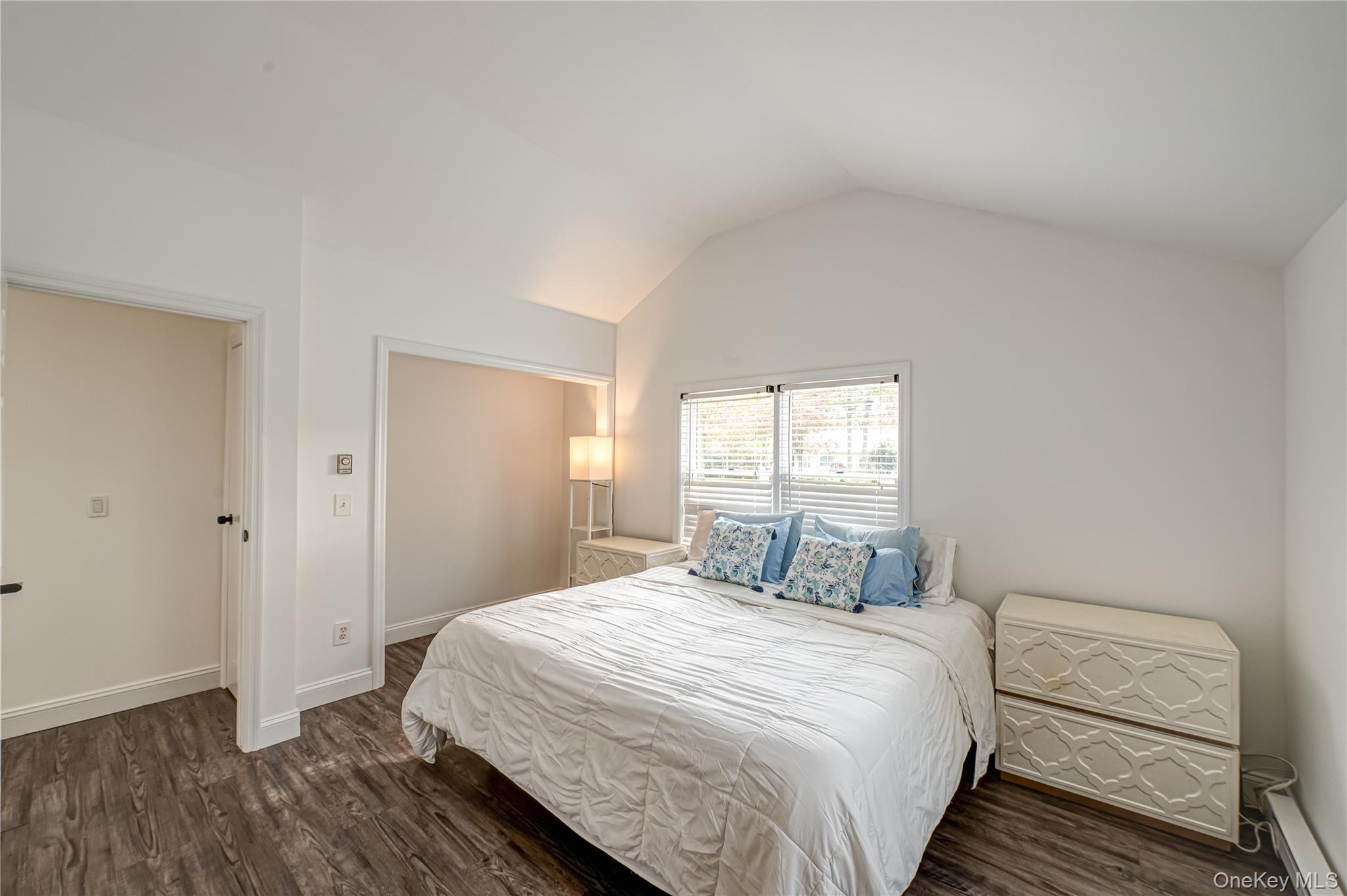 39 Lynncliff Road Hampton Bays, NY 11946 - Photo 18 of 34 Bedroom with dark wood-type flooring, vaulted ceiling, and a baseboard radiator