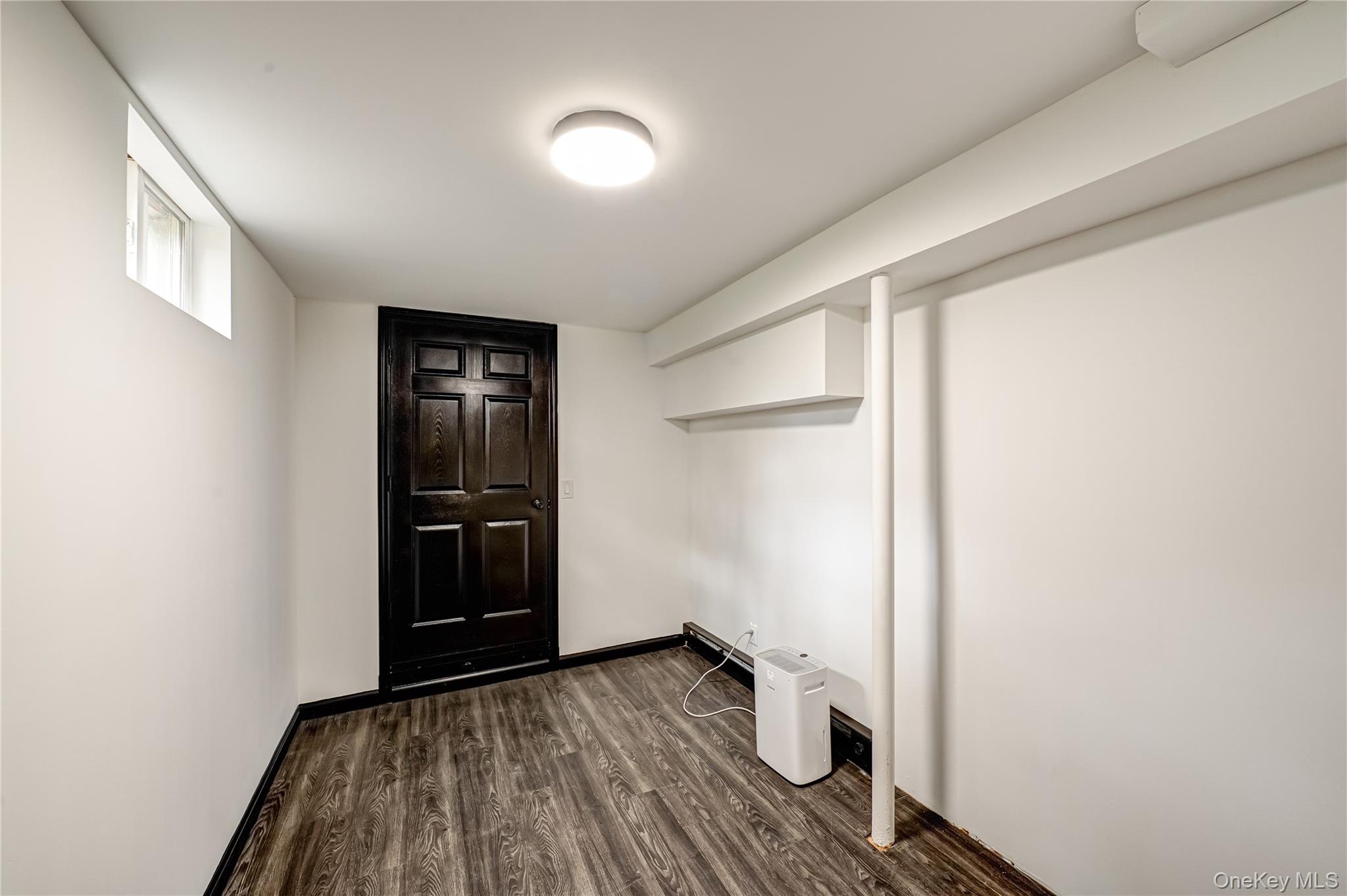 39 Lynncliff Road Hampton Bays, NY 11946 - Photo 24 of 34 Laundry room with dark wood-style flooring and baseboards