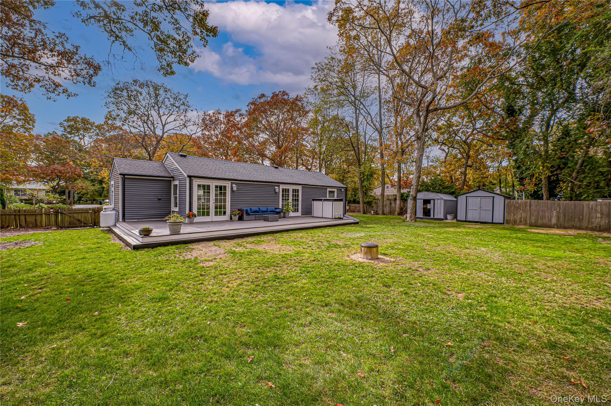 39 Lynncliff Road Hampton Bays, NY 11946 - Photo 27 of 34 Rear view of property featuring a fenced backyard, french doors, a storage unit, and a deck