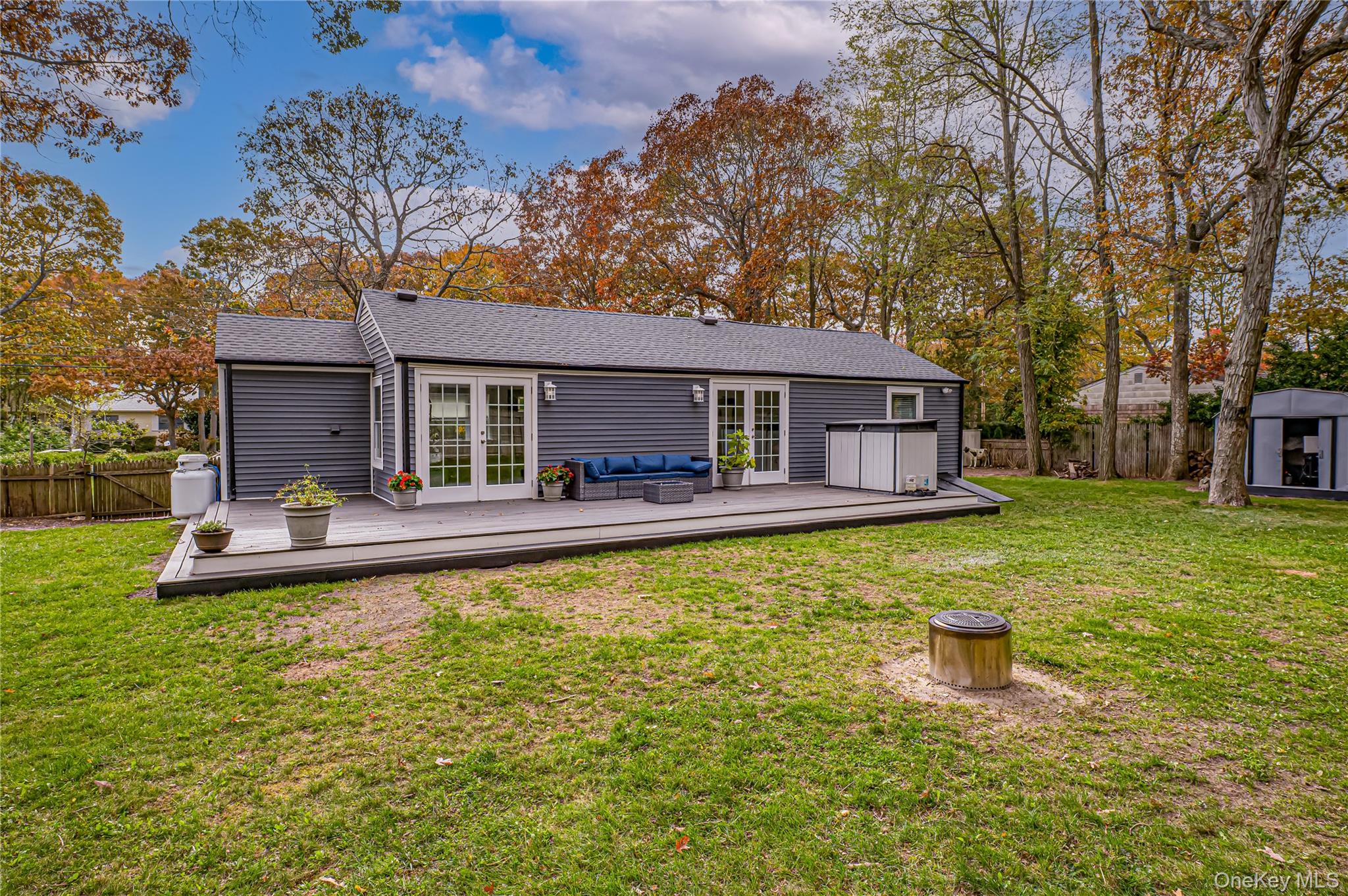 39 Lynncliff Road Hampton Bays, NY 11946 - Photo 28 of 34 Rear view of house featuring a fenced backyard, a wooden deck, and a shingled roof
