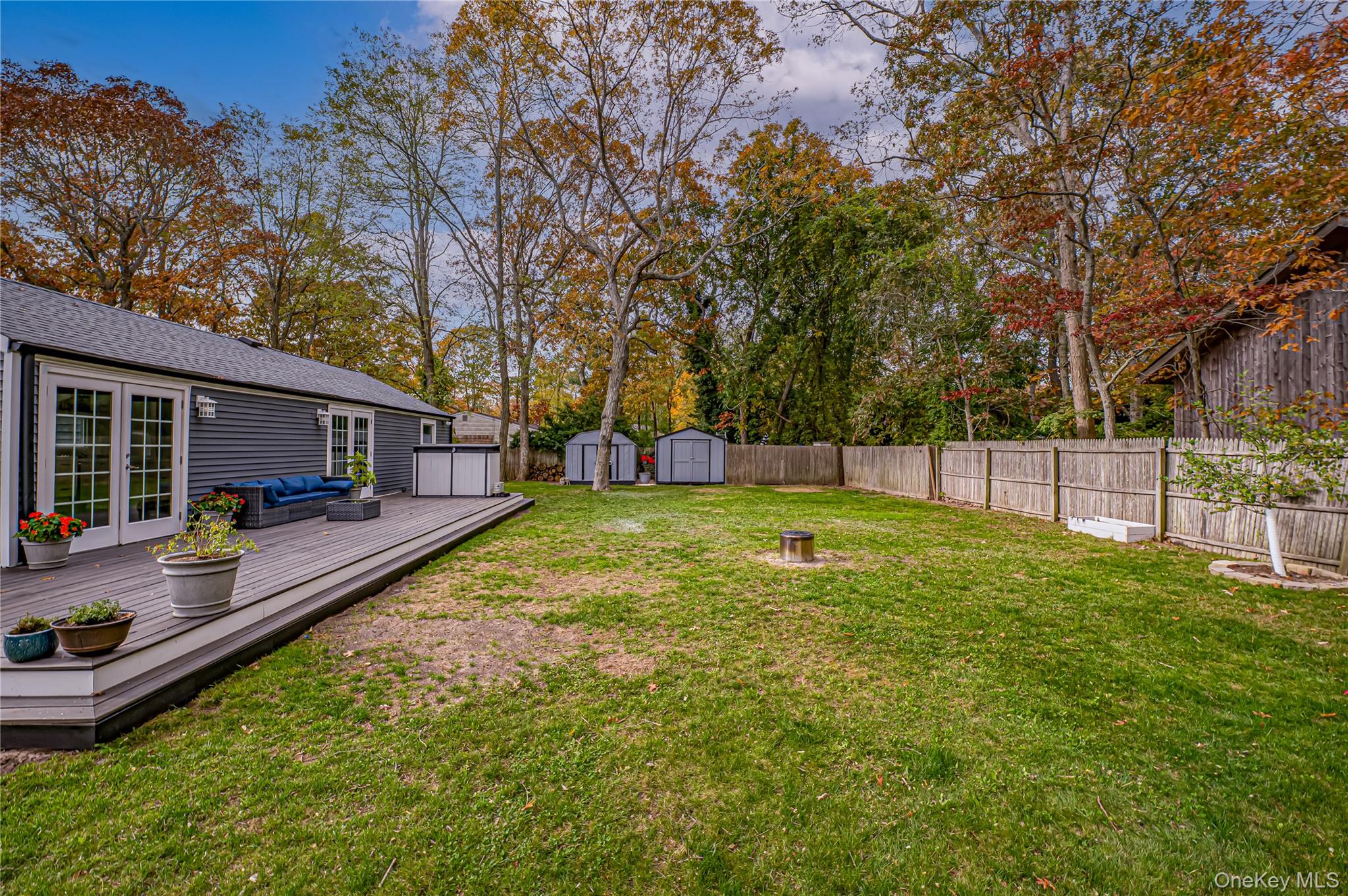 39 Lynncliff Road Hampton Bays, NY 11946 - Photo 29 of 34 Fenced backyard featuring a wooden deck, a shed, an outdoor living space, french doors, and view of wooded area