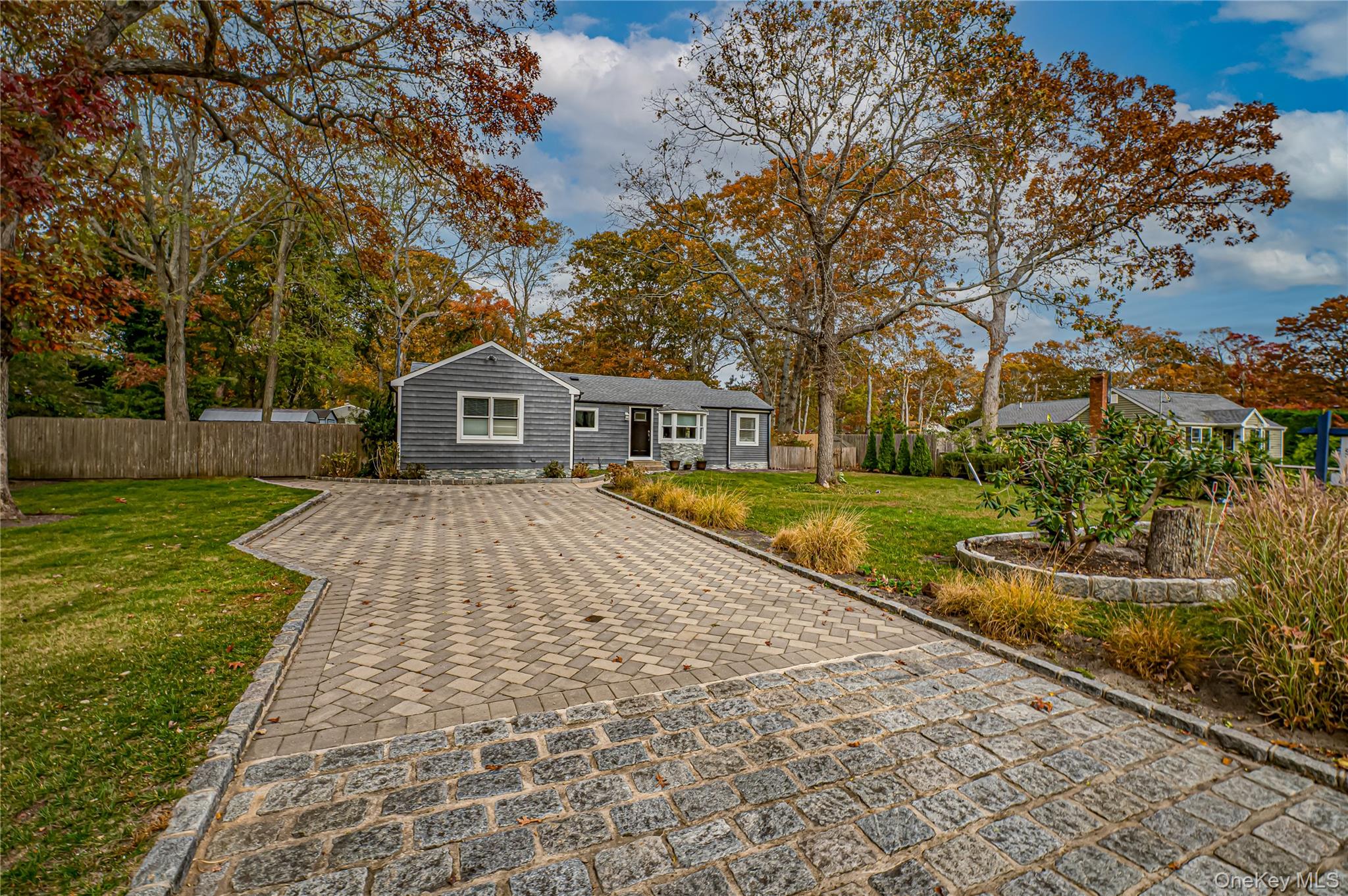 39 Lynncliff Road Hampton Bays, NY 11946 - Photo 4 of 34 View of front of property with decorative driveway and view of wooded area
