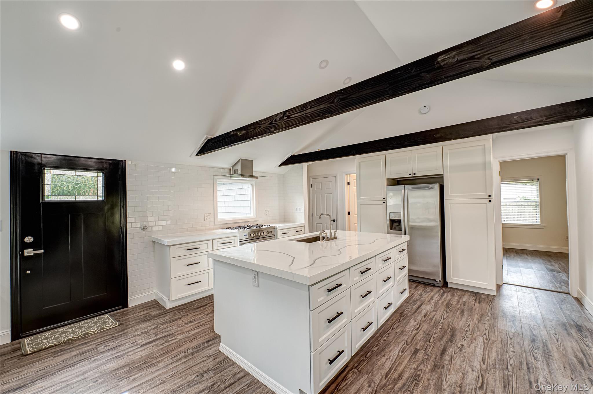 39 Lynncliff Road Hampton Bays, NY 11946 - Photo 7 of 34 Kitchen featuring healthy amount of natural light, white cabinetry, appliances with stainless steel finishes, and recessed lighting