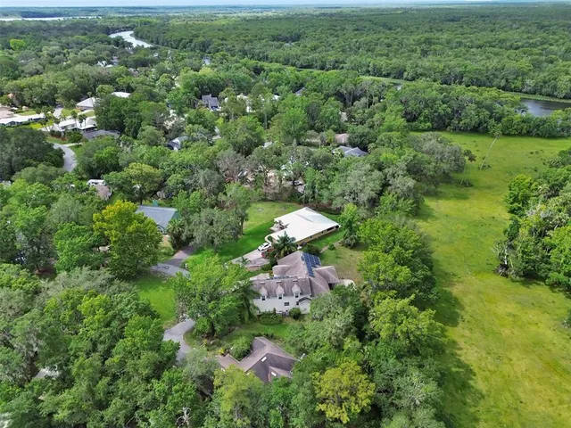 an aerial view of a house with a yard and lake view