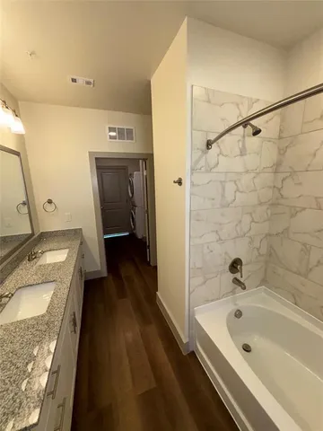 a bathroom with a granite countertop sink a bathtub and shower