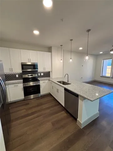 a large kitchen with granite countertop a stove and a sink