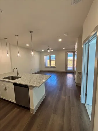 a large kitchen with stainless steel appliances granite countertop a lot of counter space and wooden floors