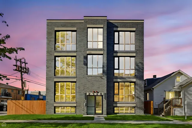 a front view of a residential apartment building with a yard
