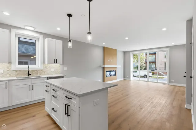 a kitchen with a sink stove and wooden floor
