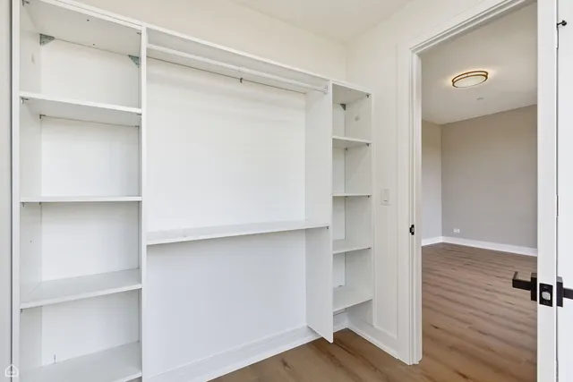 a view of walk in closet with empty racks
