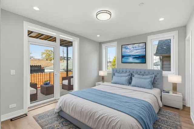 a bedroom with a balcony a bed and a painting on the wall