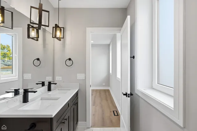 a bathroom with double vanity sink a mirror a vanity and shower