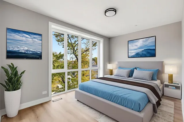 a bedroom with a large bed and a potted plant