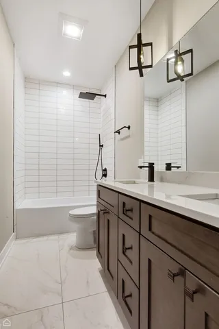 a bathroom with a sink a toilet a mirror and shower