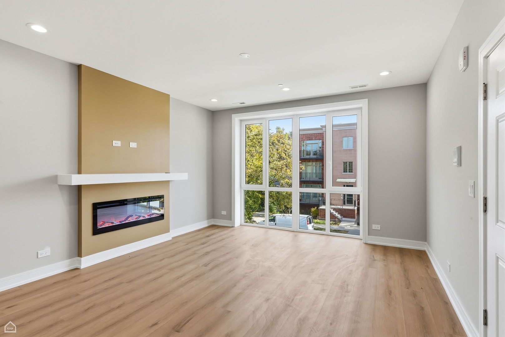 2718 Budd Street, Unit 2N River Grove, IL 60171 - Photo 6 of 48 an empty room with wooden floor fireplace and windows
