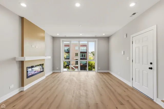 a view of an empty room with a fireplace and a window