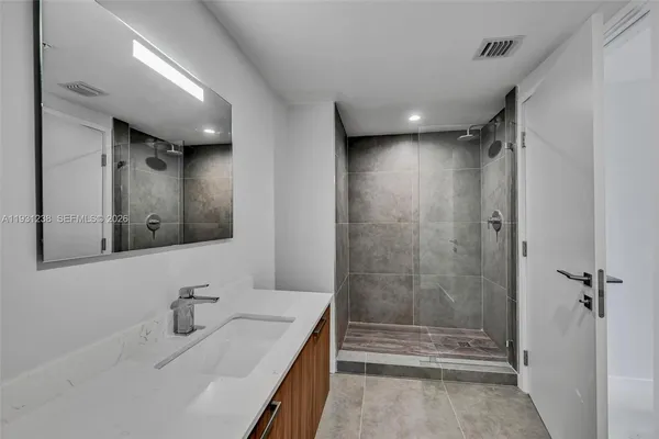 a bathroom with a toilet a sink a mirror and a window