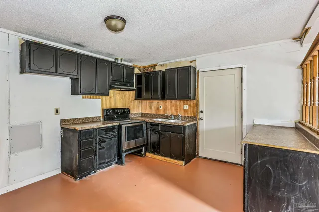 a kitchen with a refrigerator and a stove top oven