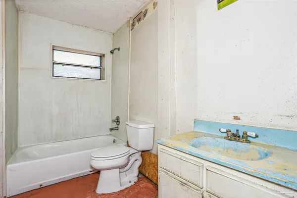 a bathroom with a granite countertop sink a toilet and bathtub