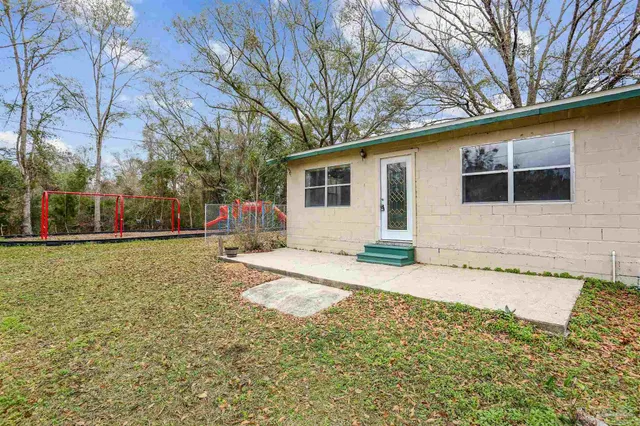 a front view of house with yard and trees around