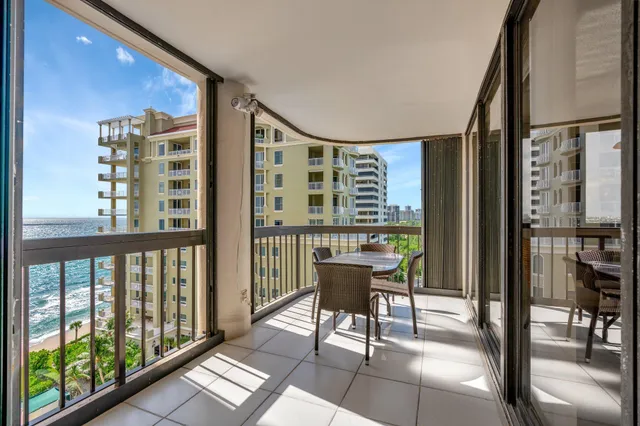 a view of a balcony with dining table and chairs