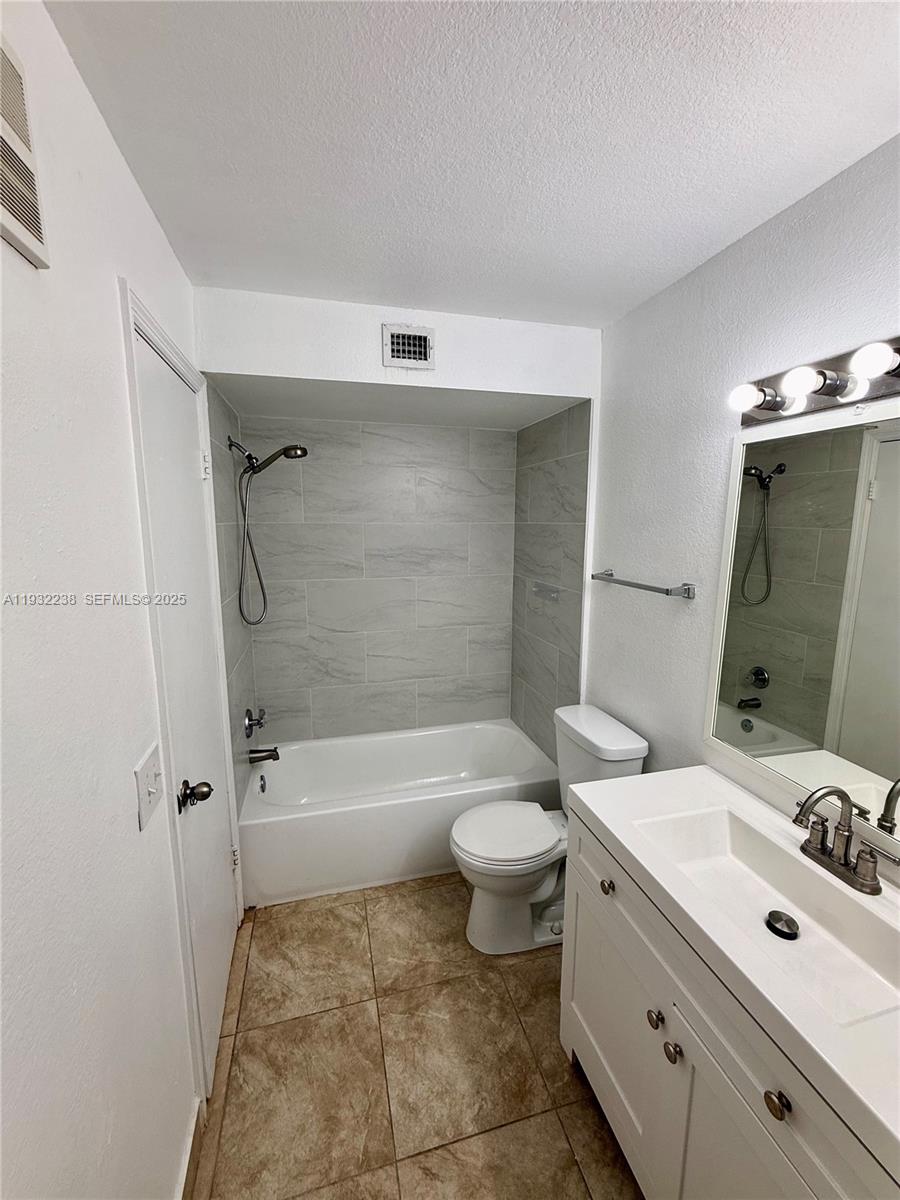 595 Vista Isles Drive, Unit 1923 Sunrise, FL 33325 - Photo 14 of 18 a bathroom with a sink mirror toilet and bathtub