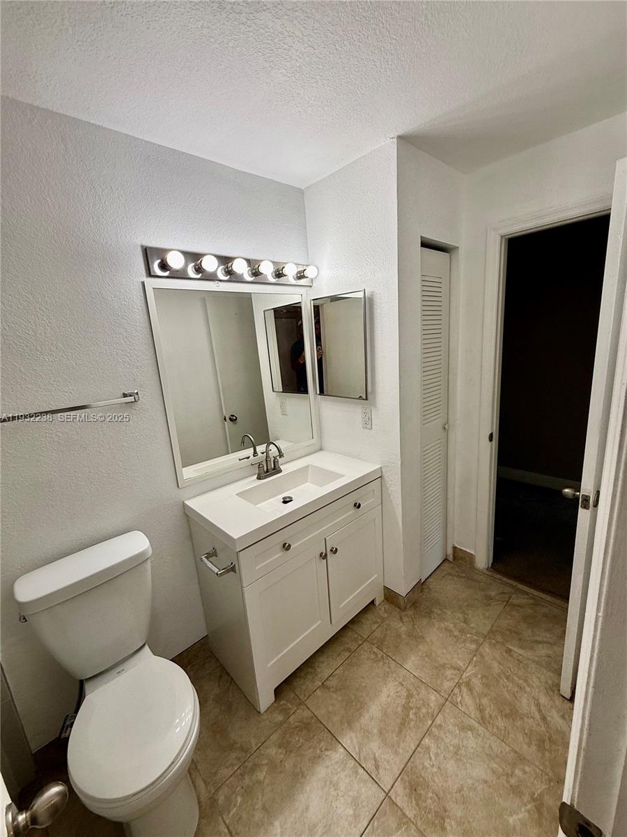 595 Vista Isles Drive, Unit 1923 Sunrise, FL 33325 - Photo 15 of 18 a bathroom with a toilet sink and mirror