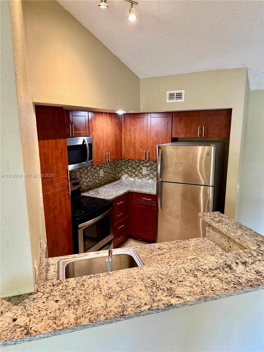595 Vista Isles Drive, Unit 1923 Sunrise, FL 33325 - Photo 6 of 18 a kitchen with a refrigerator and a sink
