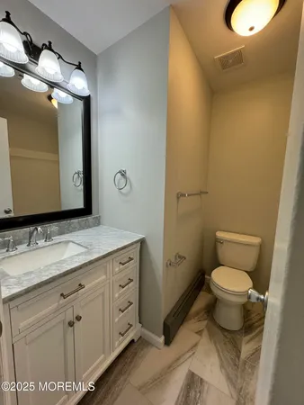a bathroom with a granite countertop sink and a mirror