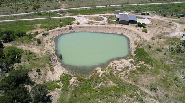 an aerial view of a house with a yard and lake view