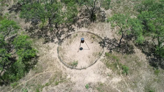 an aerial view of a highlighted house in a forest