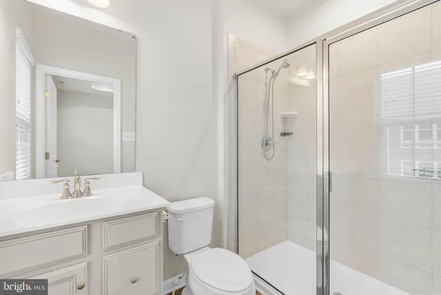a bathroom with a sink mirror vanity and toilet