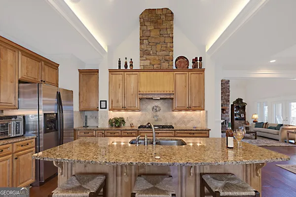 a kitchen with stainless steel appliances granite countertop a stove refrigerator and cabinets