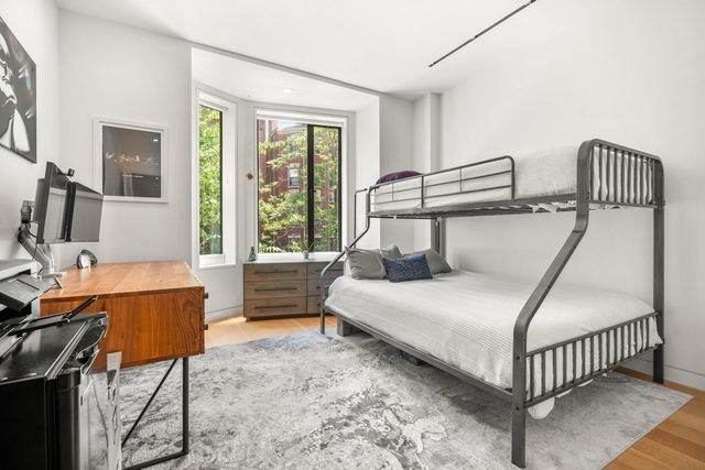 a bedroom with a bed and a large window