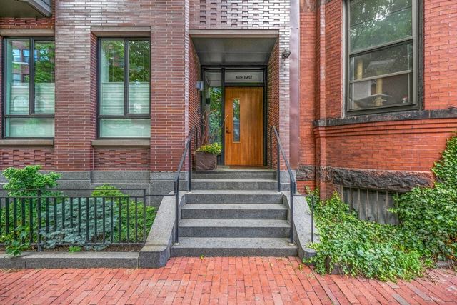 a view of a brick house with plants