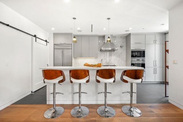 a kitchen with stainless steel appliances kitchen island granite countertop a table and chairs