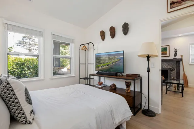 a bedroom with a bed and a flat tv screen on dresser