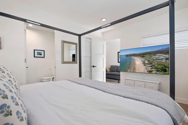 a bedroom with a large bed and a flat screen tv