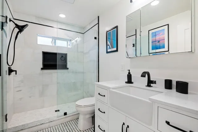 a bathroom with a sink a toilet and shower