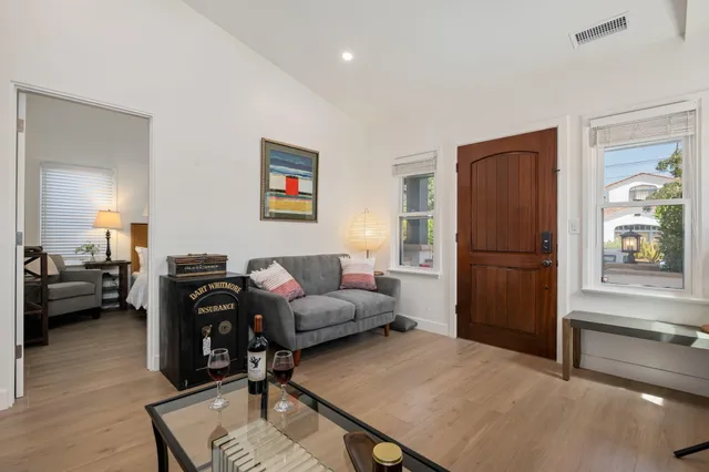 a living room with furniture and a refrigerator