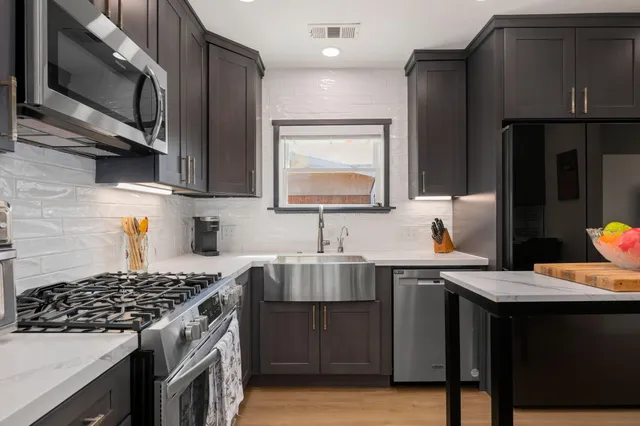 a kitchen with stainless steel appliances a sink stove and refrigerator