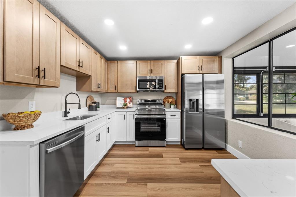 117 Poinciana Road Edgewater, FL 32141 - Photo 11 of 36 a kitchen with stainless steel appliances granite countertop a refrigerator and a stove top oven
