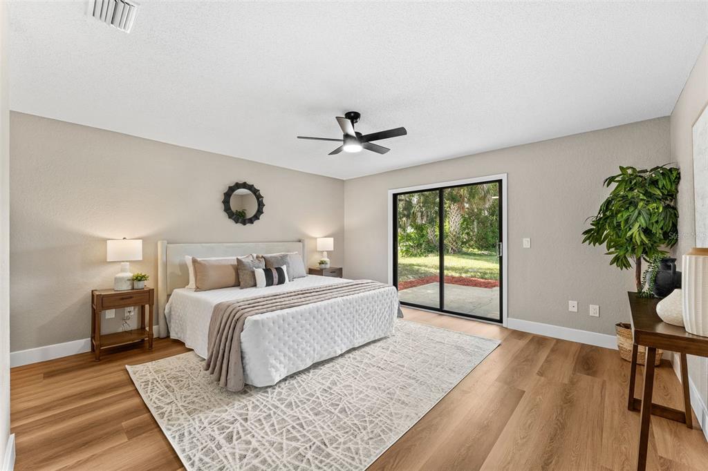 117 Poinciana Road Edgewater, FL 32141 - Photo 15 of 36 a bedroom with a large bed and a chandelier