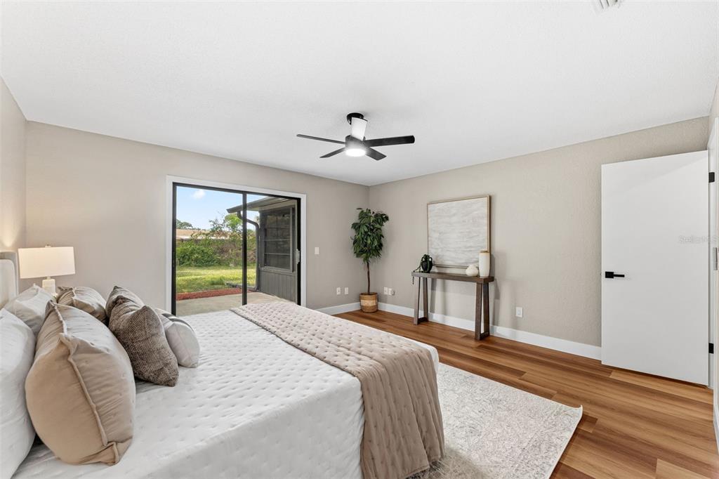 117 Poinciana Road Edgewater, FL 32141 - Photo 16 of 36 a bedroom with a large bed and a chandelier