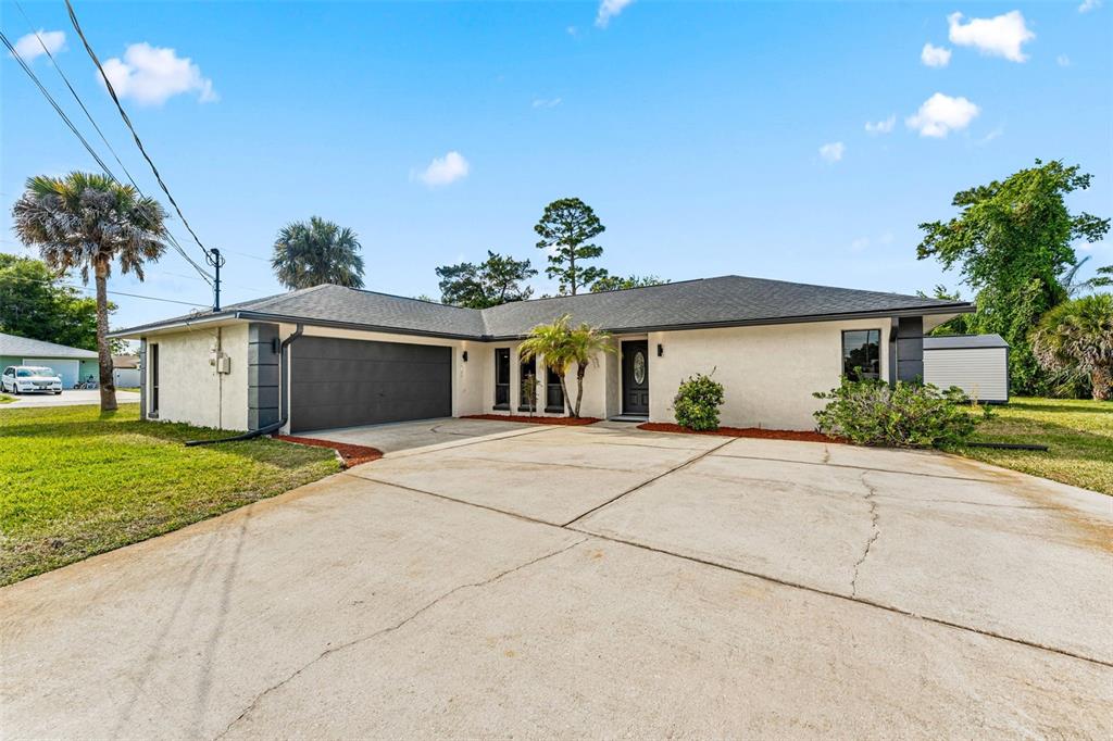117 Poinciana Road Edgewater, FL 32141 - Photo 3 of 36 a front view of a house with garden