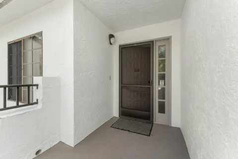 a view of a hallway with wooden floor and windows
